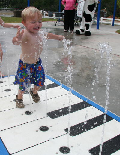 Child Laughing Running Across Piano Key Splash Pad